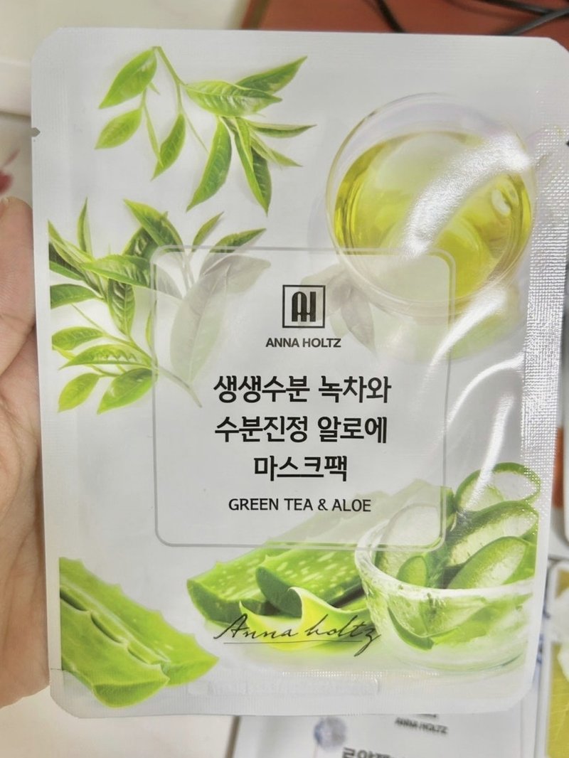 녹차 알로에 마스크팩 파우치를 손에 든 모습