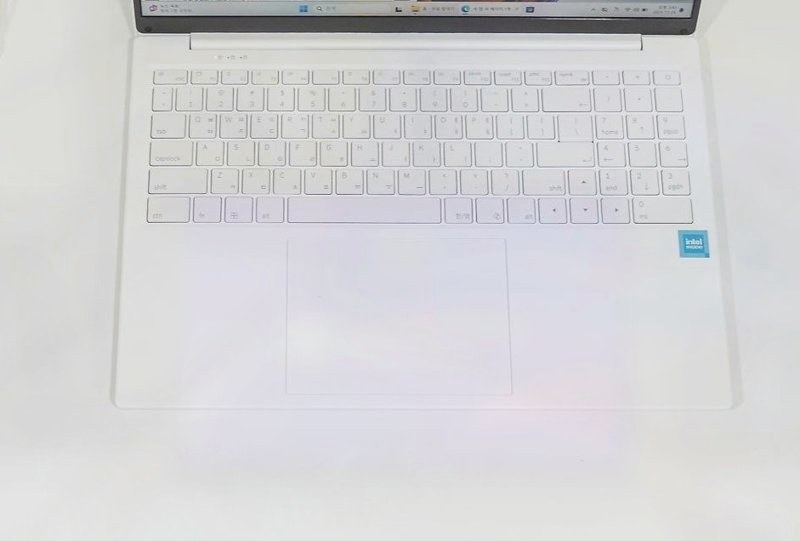 흰색 노트북 키보드와 넓은 터치패드를 위에서 본 모습, 오른쪽에 숫자 키패드가 있음