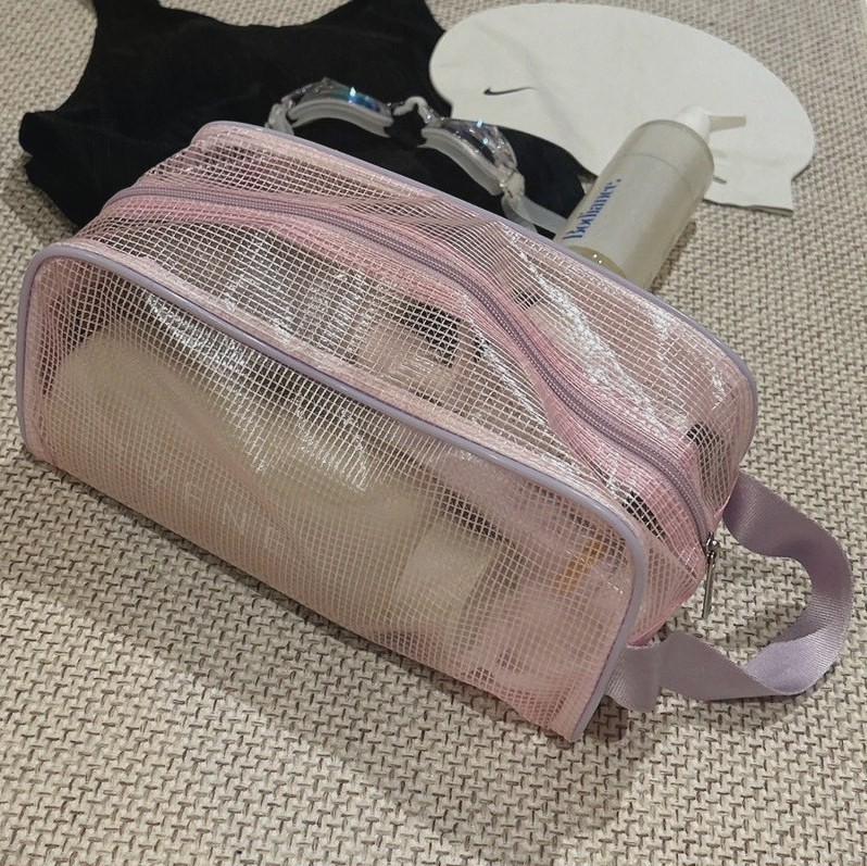 분홍 망사 목욕 파우치에 수경과 샴푸 병이 들어 있는 모습