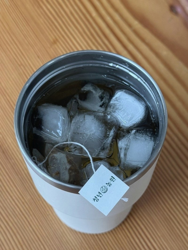 얼음을 가득 채운 텀블러 안의 호박팥차 티백