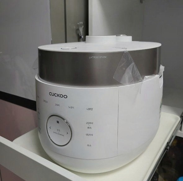 앞면에 고압취사·무압취사 글씨와 둥근 조작 버튼이 있는 흰색 밥솥