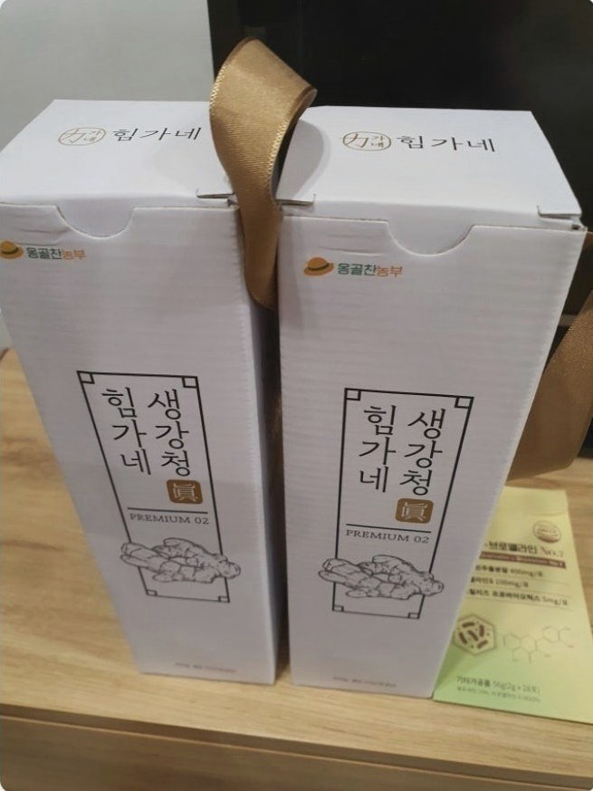 흰 상자 두 개에 금색 끈이 달린 힘가네 생강청 선물 구성