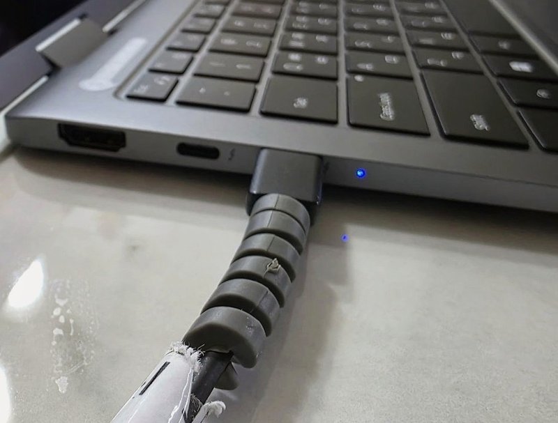노트북 옆면 USB-C 포트에 꽂힌 충전 케이블