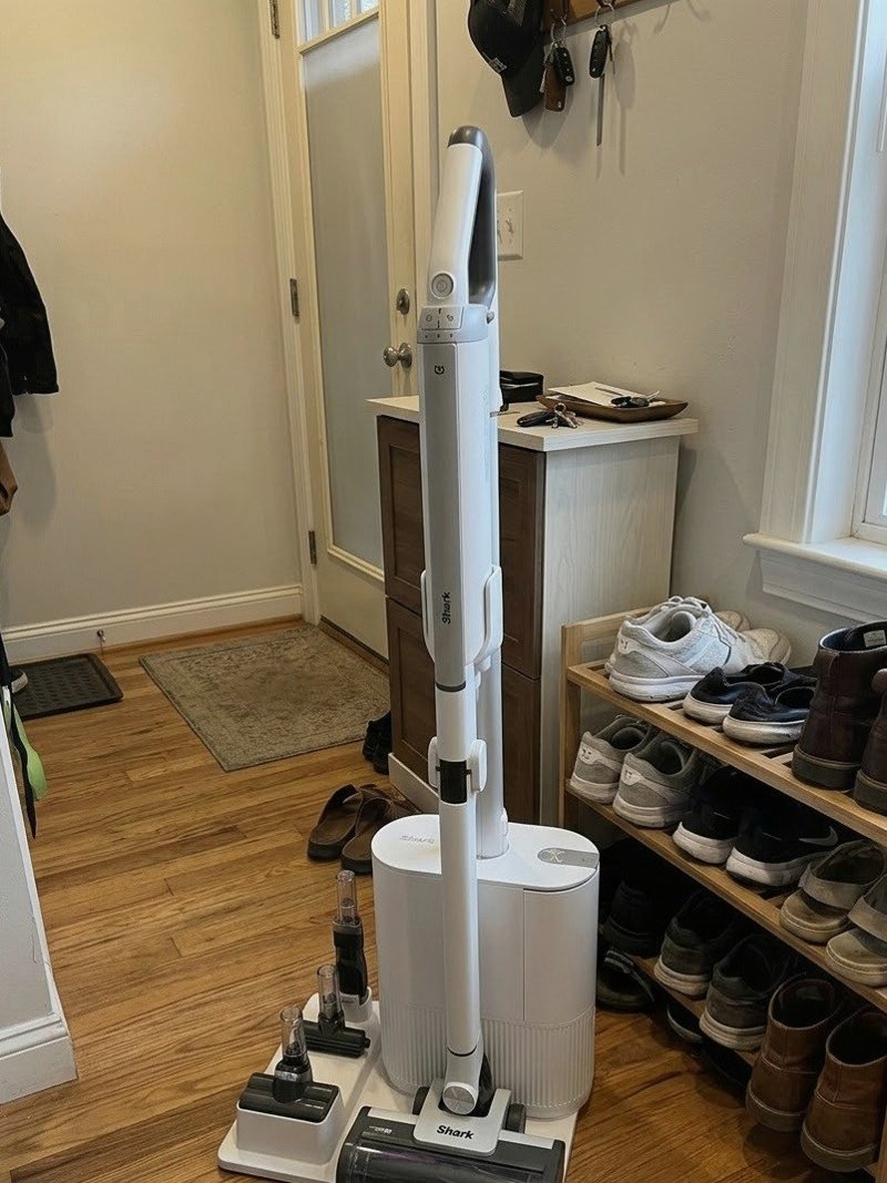 복도 신발장 옆에 세워 둔 흰색 청소기와 스테이션