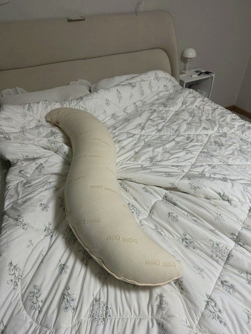 침대 위에 놓인 베이지색 S자 바디베개